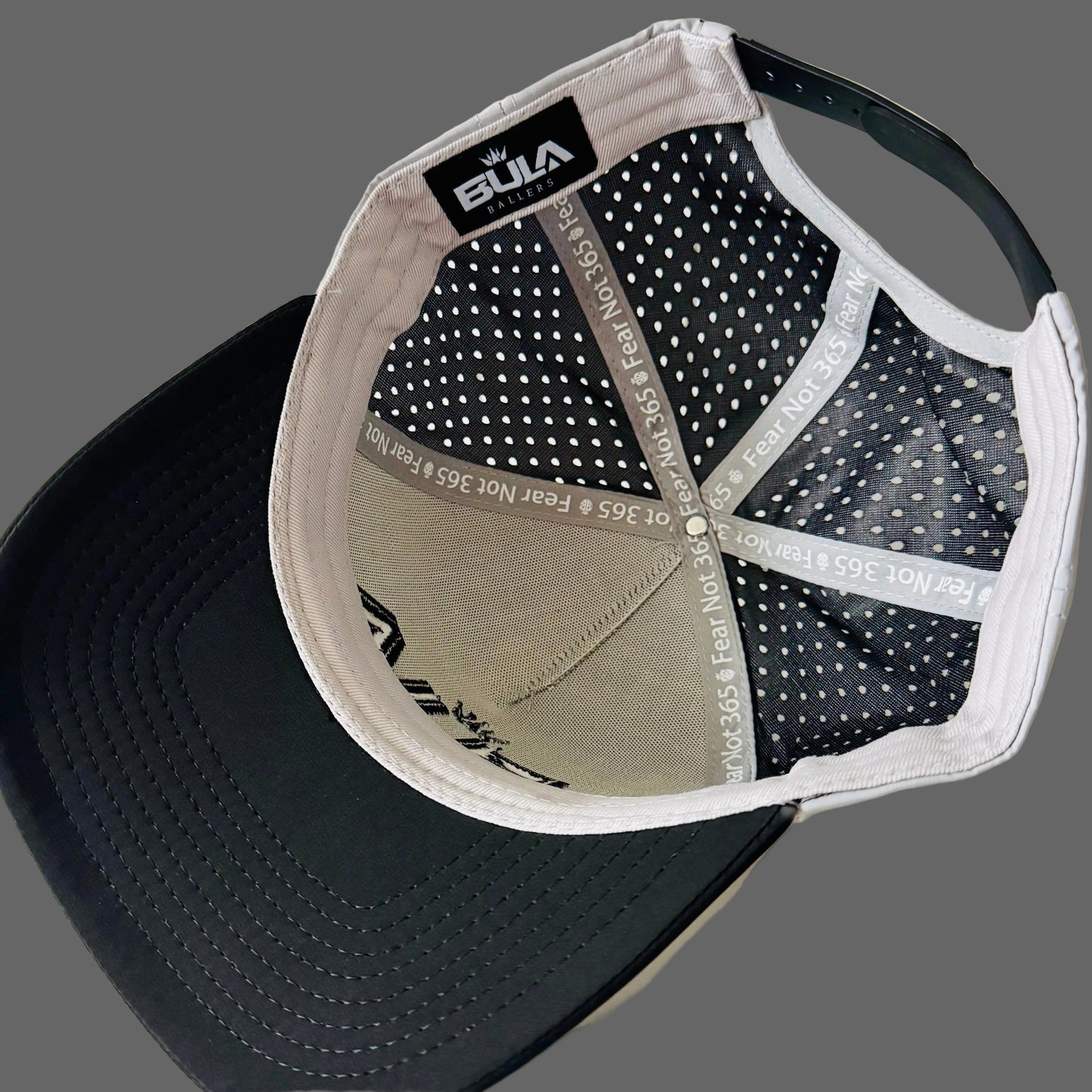 Baseball cap with black brim and gray bill on a white tiled background