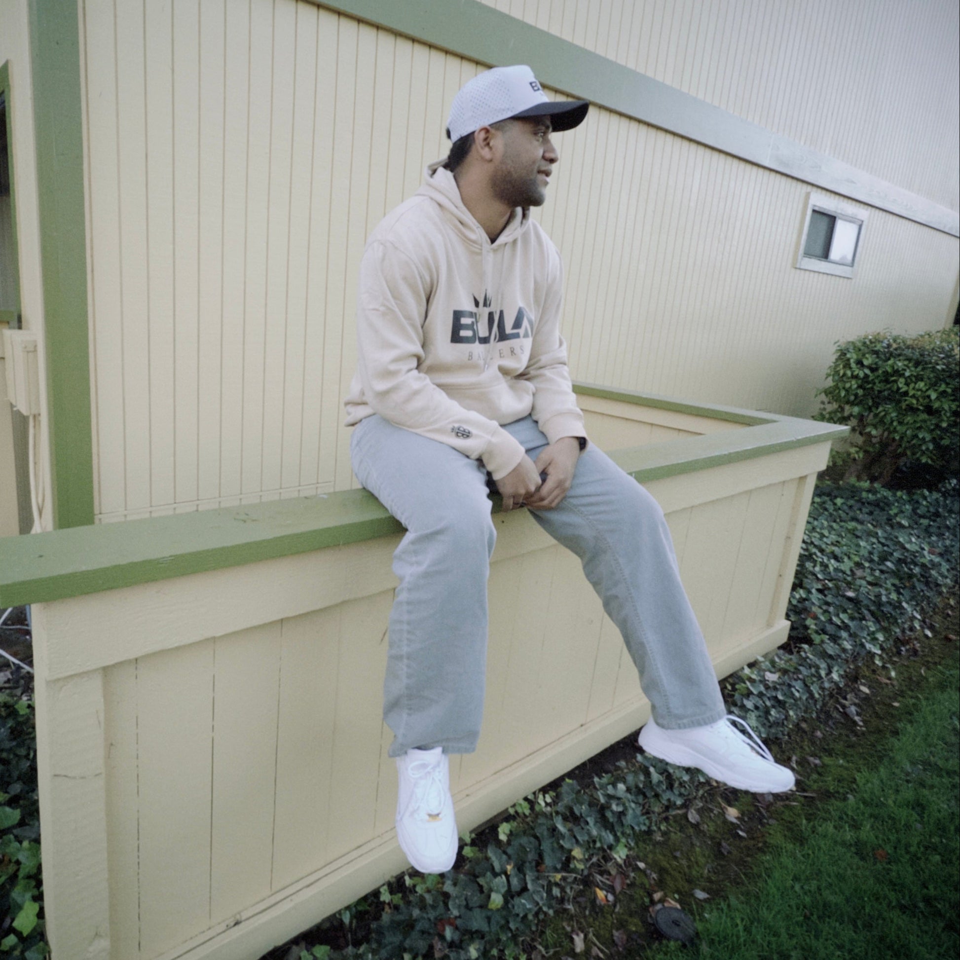 Person sitting on a ledge outside an apartment building